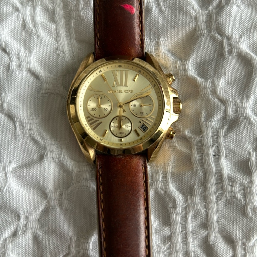 Micheal Kors gold watch with brown leather strap.